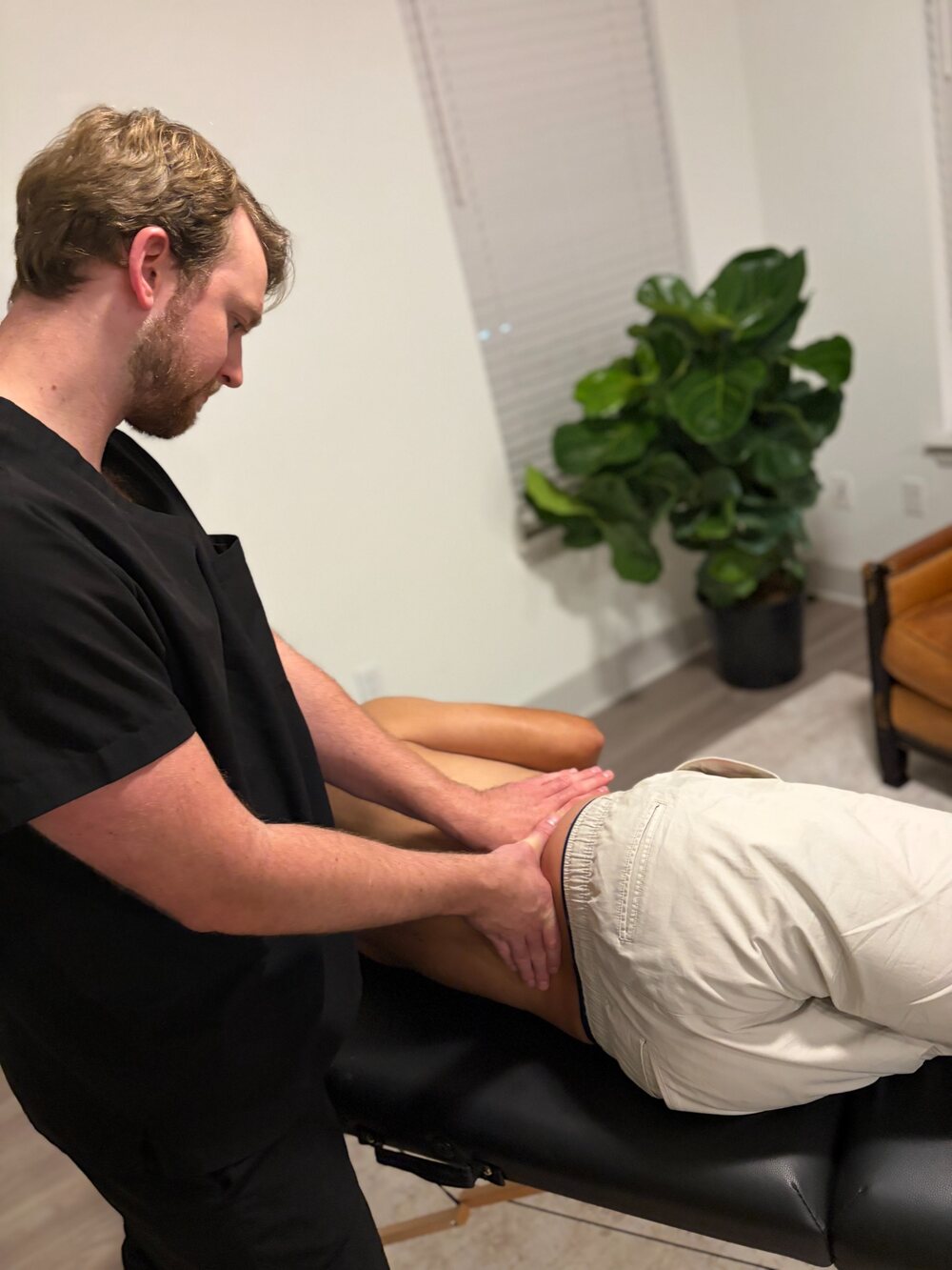 Benjamin Parker providing targeted massage during a mobile recovery session